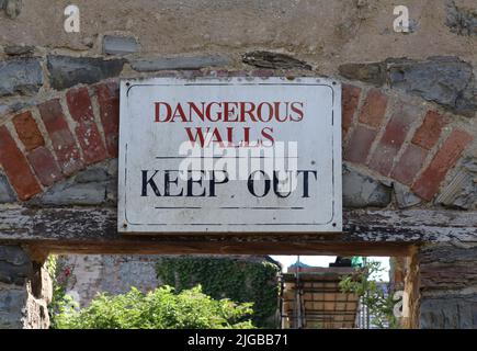 Un segno di un edificio derelitto alla periferia di Kilve in Somerset che dice alla gente di tenere fuori perché l'edificio può crollare Foto Stock