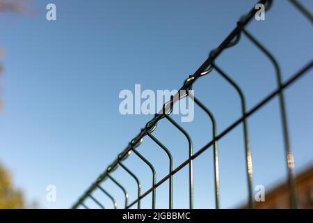 Recinzione in barre d'acciaio. Recinzione fatta di rete nel parcheggio. Rete in acciaio. Ostacolo dalla penetrazione. Foto Stock