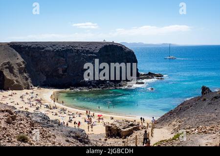 la gente si rilassa su una spiaggia di sabbia bianca con una scogliera ripida Foto Stock