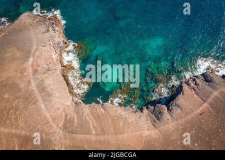 vista aerea di costa alta e ripida onde che si infrangono sulle scogliere Foto Stock