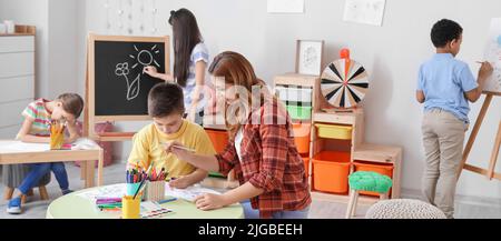 Insegnante di disegno che dà le lezioni a scuola Foto Stock