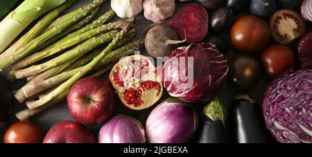 Varie verdure fresche con frutta su sfondo scuro Foto Stock