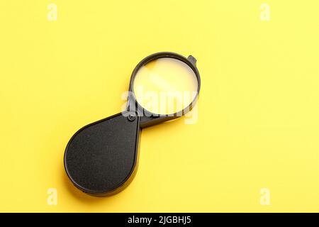 Lente di ingrandimento su sfondo giallo Foto Stock