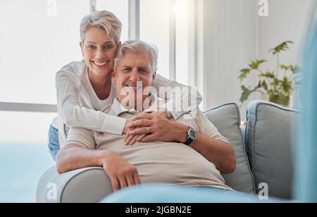 Weve sempre stato in esso per il lungo raggio. Ritratto corto di una coppia anziana affettuosa che si rilassa nel loro soggiorno a casa. Foto Stock