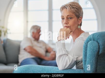 Ne è valsa la pena: Una coppia anziana, dopo un'argomentazione, ha un aspetto triste e sconvolto mentre si siede nel soggiorno. Foto Stock