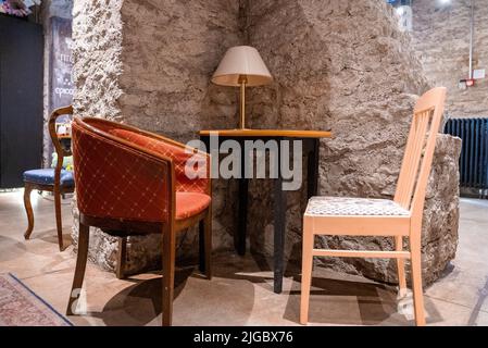 Sedie confortevoli e tavolo disposti contro la parete in un elegante resort di lusso Foto Stock