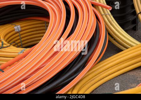 Installazioni di sviluppo di comunicazioni, bobine grandi di tubo in PVC plastica. Tubi in cantiere proteggono i cavi in impianti elettrici Foto Stock