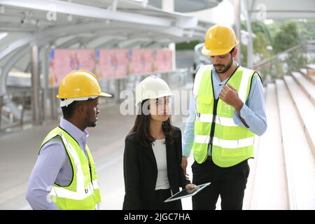 Architect, civil engineer and worker looking at plans and blueprints, discussing issues at the construction site. Stock Photo