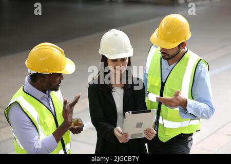 Architect, civil engineer and worker looking at plans and blueprints, discussing issues at the construction site. Stock Photo