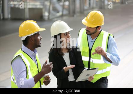 Architect, civil engineer and worker looking at plans and blueprints, discussing issues at the construction site. Stock Photo