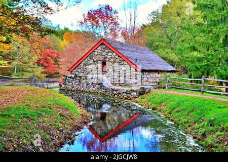 Il retro del Mulino Grist situato a Sudbury, Massachusetts, che riflette in Grist Mill Pond Foto Stock