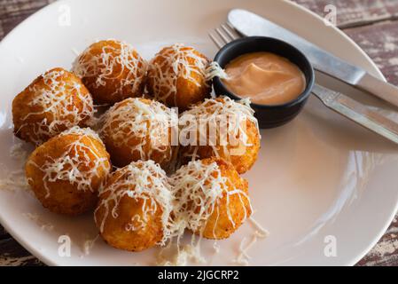 Arancini italiani. Polpette di riso fatte in casa con mozzarella, prezzemolo, limone e parmigiano. Palle di formaggio fritte con salsa Foto Stock