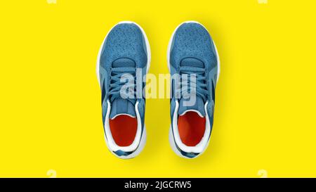 Le sneakers blu si avvicinano dall'alto. Scarpe sportive da running su sfondo giallo con spazio copia. Il concetto di jogging per uno stile di vita sano. Modalità Foto Stock