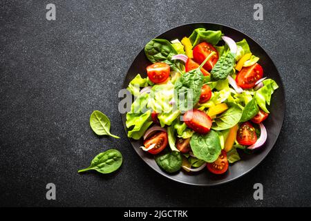 Foglie di insalata verde in una ciotola sul tavolo nero