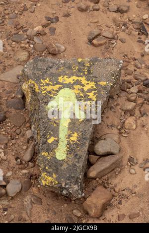 Freccia gialla dipinta su una pietra, lungo il Camino Frances, Camino de Santiago de Compostela, Spagna Foto Stock