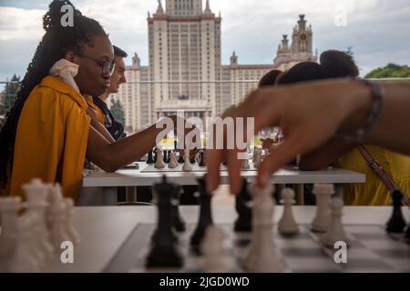 Mosca, Russia. 9th luglio 2022. La gente gioca a scacchi sullo sfondo dell'edificio alto dell'Università di Stato di Mosca nella celebrazione del giorno del trasporto di Mosca di Vorobyovy Gory, Russia. Nikolay Vinokurov/Alamy Live News Foto Stock