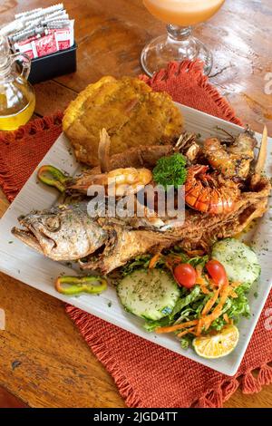 Pesce fritto intero con insalata e plantain fritto Foto Stock