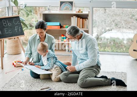 La famiglia non è una cosa importante. È tutto. Due genitori che giocano con il loro figlio a casa. Foto Stock