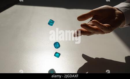 La donna lancia un paio di dadi trasparenti blu. Foto Stock