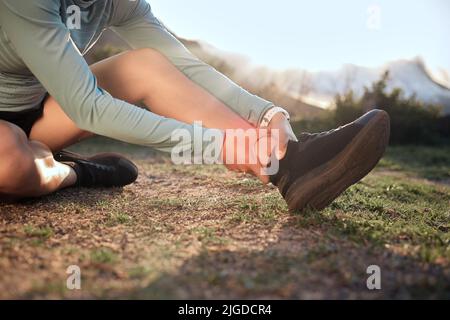 Il mio ginocchio sta piangendo di aiuto, una donna che massaggiava la caviglia dopo una corsa. Foto Stock