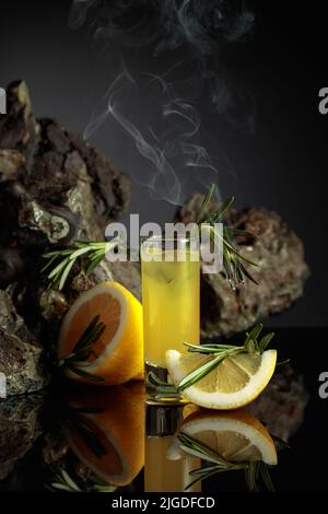 Limoncello al liquore tradizionale italiano al limone e limoni freschi su sfondo nero riflettente. Liquore con fette di limone, ghiaccio, e un fros profumante Foto Stock