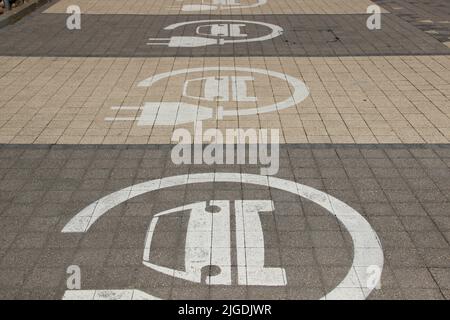 Parcheggio solo per auto elettriche. Le stazioni di ricarica sono in fila. Cartello auto elettrica. Foto Stock