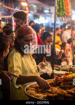 Mumbai, India - 1 maggio 2022 : il venditore musulmano maschio che cucina vende gli alimenti halal ed i Kabab dallo stallo stradale al mercato notturno nel mese santo del Ramadan. Foto Stock