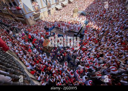 La gente partecipa alla processione di San Fermin durante le tradizionali festività di San Fermin a Pamplona, Spagna, 07 luglio 2022. Il festival, conosciuto localmente come Sanfermines, si svolge ogni anno dal 6 al 14 luglio in commemorazione del santo patrono della città. Centinaia di migliaia di visitatori da tutto il mondo partecipano al festival. Molti di loro partecipano fisicamente all'evento più importante, la corrida o l'encierrano, dove cercano di fuggire dai tori lungo un percorso attraverso le stradine strette della città vecchia. (Foto di Ruben Albarran / PRESSINPHOTO) Foto Stock