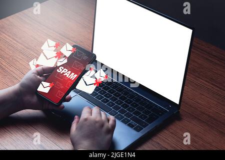 Mail spam concept su smartphone con schermo laptop mockup. Tecnologia aziendale di comunicazione. Proteggere la posta indesiderata dalla cyber sicurezza su Internet. Foto Stock