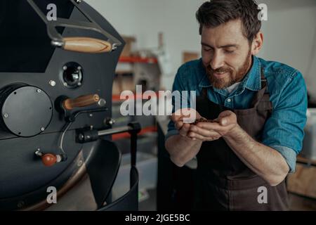 Titolare di azienda controllo dell'aroma di caffè tostato bean Foto Stock