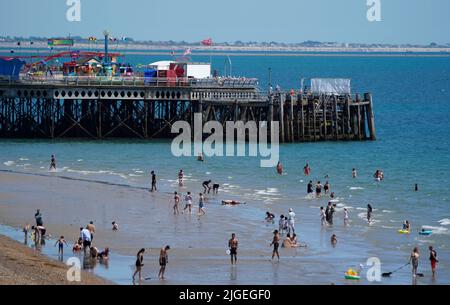 La gente gode del caldo tempo sulla spiaggia di Southsea in Hampshire. Data foto: Domenica 10 luglio 2022. Foto Stock