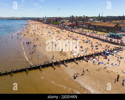 Portobello, Edimburgo, Scozia, Regno Unito. 10 luglio 2022. Una vista aerea di migliaia di amanti del sole sulla spiaggia di Portobello oggi con l'aumento delle temperature a 27C. La famosa spiaggia e il lungomare fuori Edimburgo sono stati a lungo un magnete per gli abitanti della città in estate. Iain Masterton/Alamy Live News Foto Stock