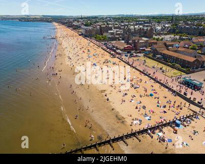 Portobello, Edimburgo, Scozia, Regno Unito. 10 luglio 2022. Una vista aerea di migliaia di amanti del sole sulla spiaggia di Portobello oggi con l'aumento delle temperature a 27C. La famosa spiaggia e il lungomare fuori Edimburgo sono stati a lungo un magnete per gli abitanti della città in estate. Iain Masterton/Alamy Live News Foto Stock