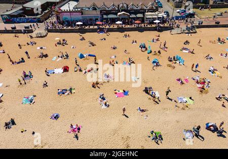 Portobello, Edimburgo, Scozia, Regno Unito. 10 luglio 2022. Una vista aerea di migliaia di amanti del sole sulla spiaggia di Portobello oggi con l'aumento delle temperature a 27C. La famosa spiaggia e il lungomare fuori Edimburgo sono stati a lungo un magnete per gli abitanti della città in estate. Iain Masterton/Alamy Live News Foto Stock