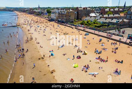 Portobello, Edimburgo, Scozia, Regno Unito. 10 luglio 2022. Una vista aerea di migliaia di amanti del sole sulla spiaggia di Portobello oggi con l'aumento delle temperature a 27C. La famosa spiaggia e il lungomare fuori Edimburgo sono stati a lungo un magnete per gli abitanti della città in estate. Iain Masterton/Alamy Live News Foto Stock