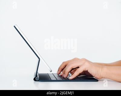 Tastiera del computer sullo schermo del tablet digitale isolata su sfondo bianco con spazio di copia. Concetto di business e tecnologia, vista laterale. Foto Stock