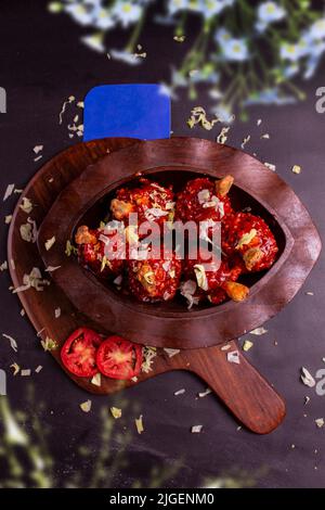 Pollo Szechuan, una ricetta popolare indocinese non vegetariana, servito in un piatto con salsa al peperoncino. Fuoco selettivo. Spazio per copie. Foto Stock