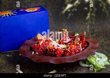 Pollo Szechuan, una ricetta popolare indocinese non vegetariana, servito in un piatto con salsa al peperoncino. Fuoco selettivo. Spazio per copie. Foto Stock