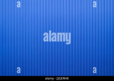 Parete esterna vuota del magazzino realizzata con superficie in metallo corrugato blu o parete in acciaio galvanizzato per edifici industriali. Acciaio inox, metallo Flo Foto Stock