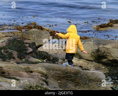 Pericolo in vacanza su rocce scivolose e il mare. Foto Stock