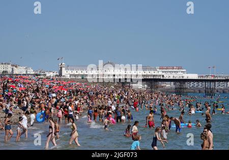 La gente gode del caldo tempo alla spiaggia di Brighton nel Sussex occidentale. Data foto: Domenica 10 luglio 2022. Foto Stock