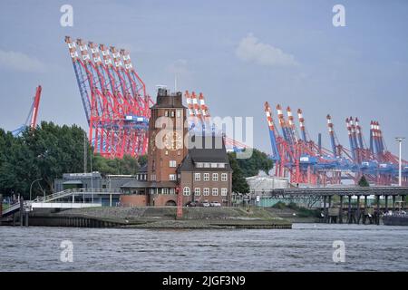 Amburgo, Germania. 15th ago 2021. La casa pilota di Seemannshöft è visibile sullo sfondo delle gru di carico del terminal dei container Burchardtkai. L'edificio in mattoni sul fiume Elba, costruito nel 1914 e ora situato vicino al molo di Finkenwerder, ospita i piloti del porto di Amburgo, il servizio di segnalazione delle navi, la sede nautica del porto e il gruppo di lavoro di fissaggio delle navi di Amburgo. Credit: Soeren Stache/dpa-Zentralbild/ZB/dpa/Alamy Live News Foto Stock