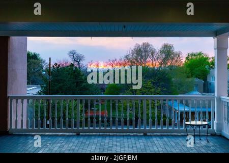 Il sole tramonta sul centro di Santa Fe Plaza e si affaccia sul patio con un piccolo tavolo ad angolo Foto Stock