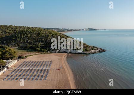 Vista aerea della spiaggia durante una mattinata estiva e la città di Vieste sullo sfondo, Puglia, Italia. Foto Stock