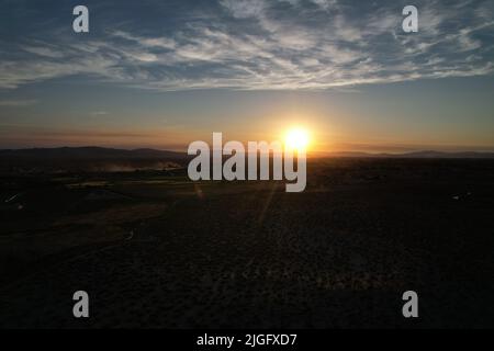 Tramonto del deserto che mostra l'intera di una piccola città agricola Foto Stock