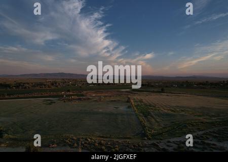 Tramonto del deserto che mostra l'intera di una piccola città agricola Foto Stock