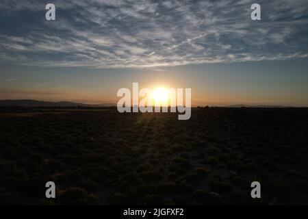 Tramonto del deserto che mostra l'intera di una piccola città agricola Foto Stock