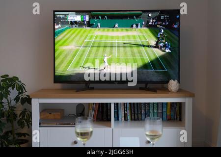 Novak Djokovic serve contro Cameron Norrie a Wimbledon 2022 uomini tennis single semifinale il 8th luglio 2022 su una tv in un salotto. REGNO UNITO Foto Stock