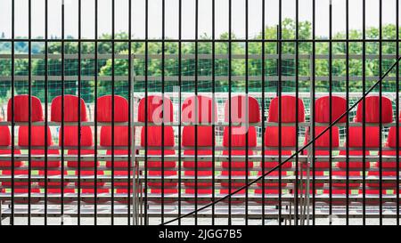 Posti a sedere vuoti, sedie di plastica file rosse nello stadio. Concetto di sport Foto Stock