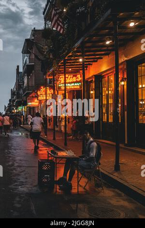 Bourboun Street di New Orleans (Louisiana) di notte, che mostra i riflessi delle luci al neon sulla strada Foto Stock